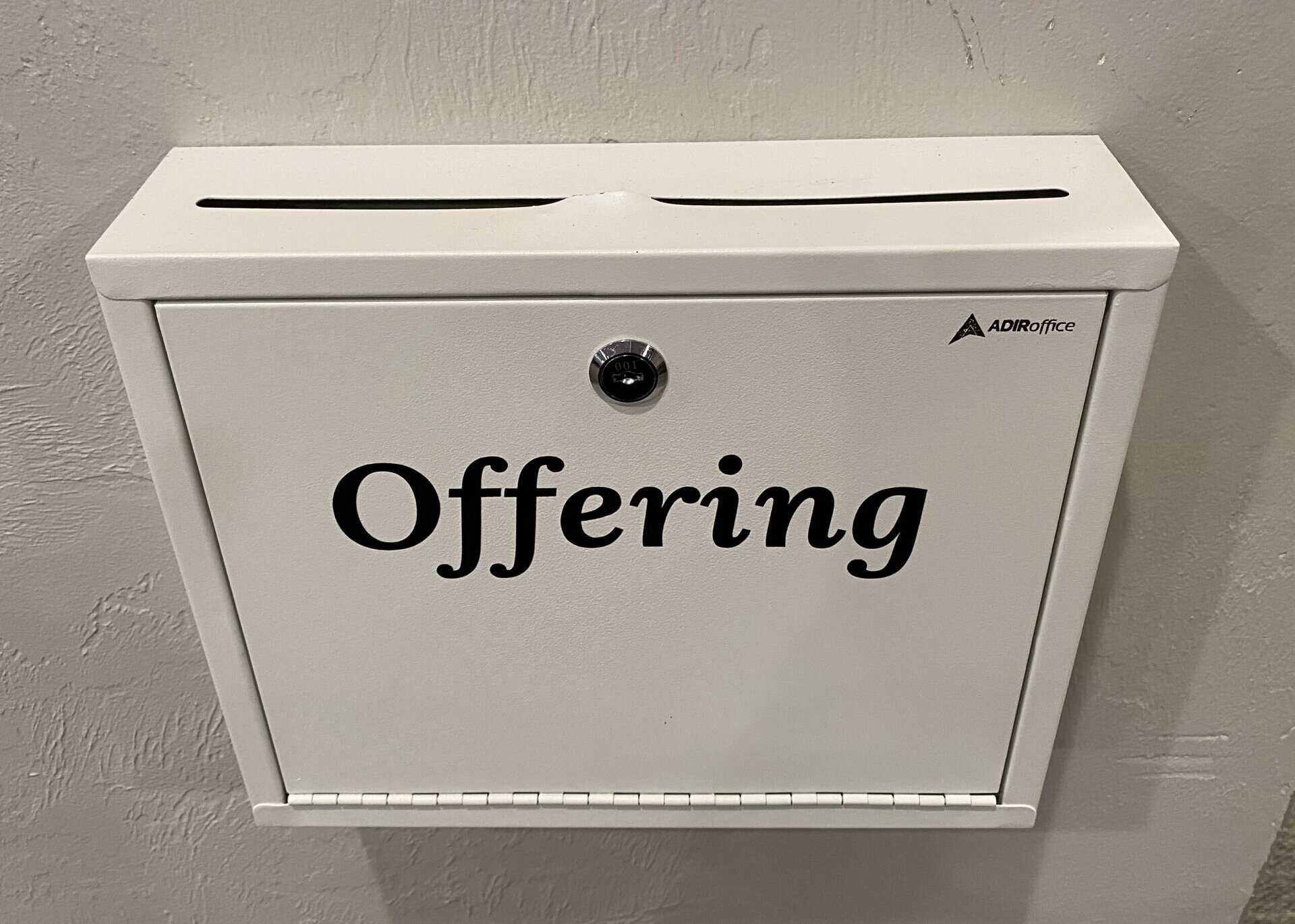 White wall-mounted offering box with a slot on top and the word "Offering" in black text on the front.